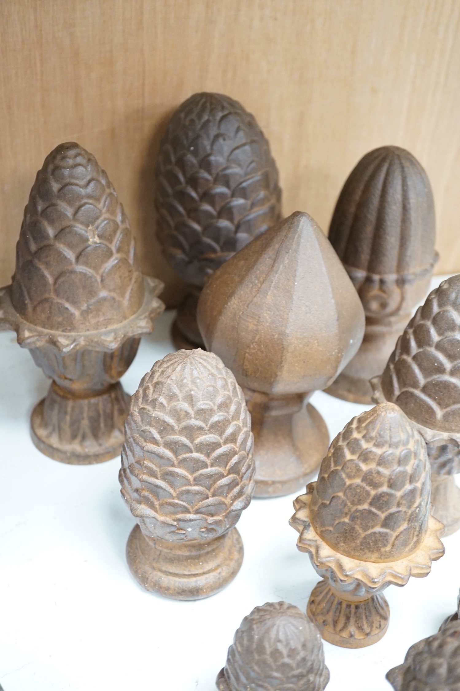 A group of cast iron finials, some with pine-cone decoration, tallest 21cm